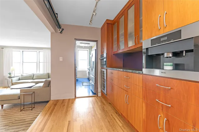 a kitchen with stainless steel appliances granite countertop a refrigerator a sink dishwasher and a stove with wooden floor