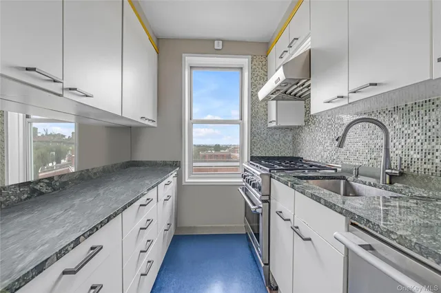 a kitchen with granite countertop a stove and a sink