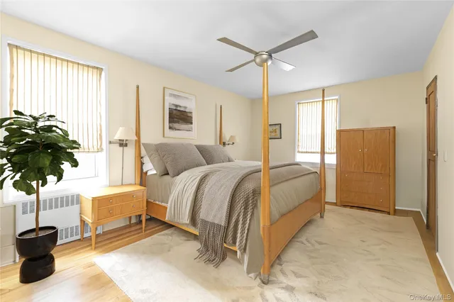 a spacious bedroom with a bed and a potted plant