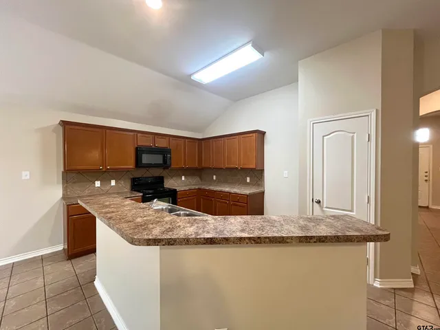a kitchen with stainless steel appliances granite countertop a sink and a stove