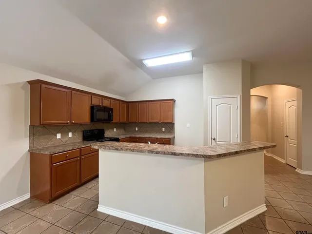 a kitchen with stainless steel appliances granite countertop a sink stove and cabinets