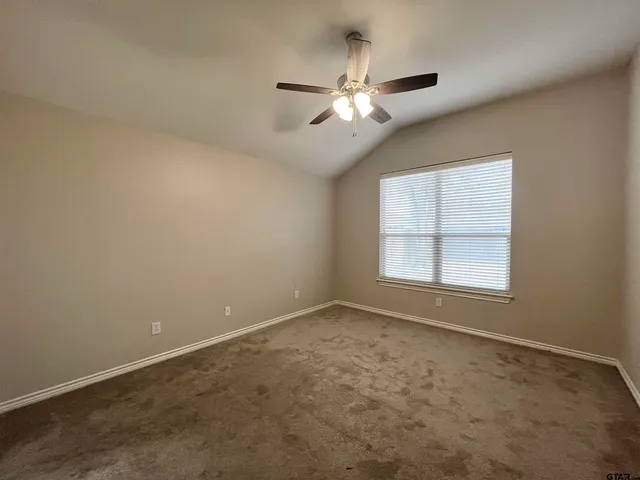 an empty room with chandelier fan