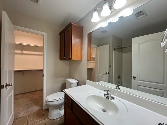 a white bath tub with shower and a sink