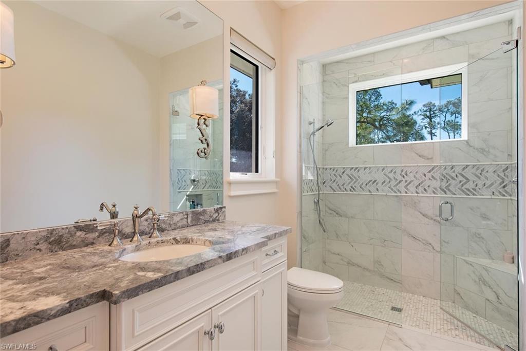 16044 Trebbio Way Naples, FL 34110 - Photo 12 of 33 a bathroom with a granite countertop sink toilet and shower