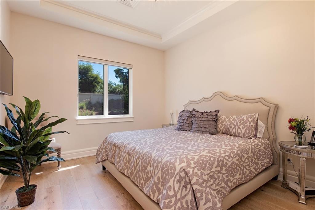 16044 Trebbio Way Naples, FL 34110 - Photo 13 of 33 a bedroom with a large bed and a potted plant