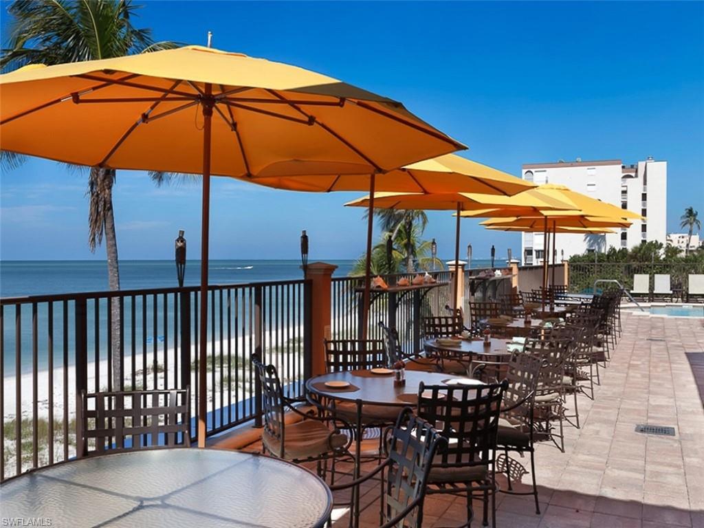 16044 Trebbio Way Naples, FL 34110 - Photo 30 of 33 a view of a patio with table and chairs under an umbrella