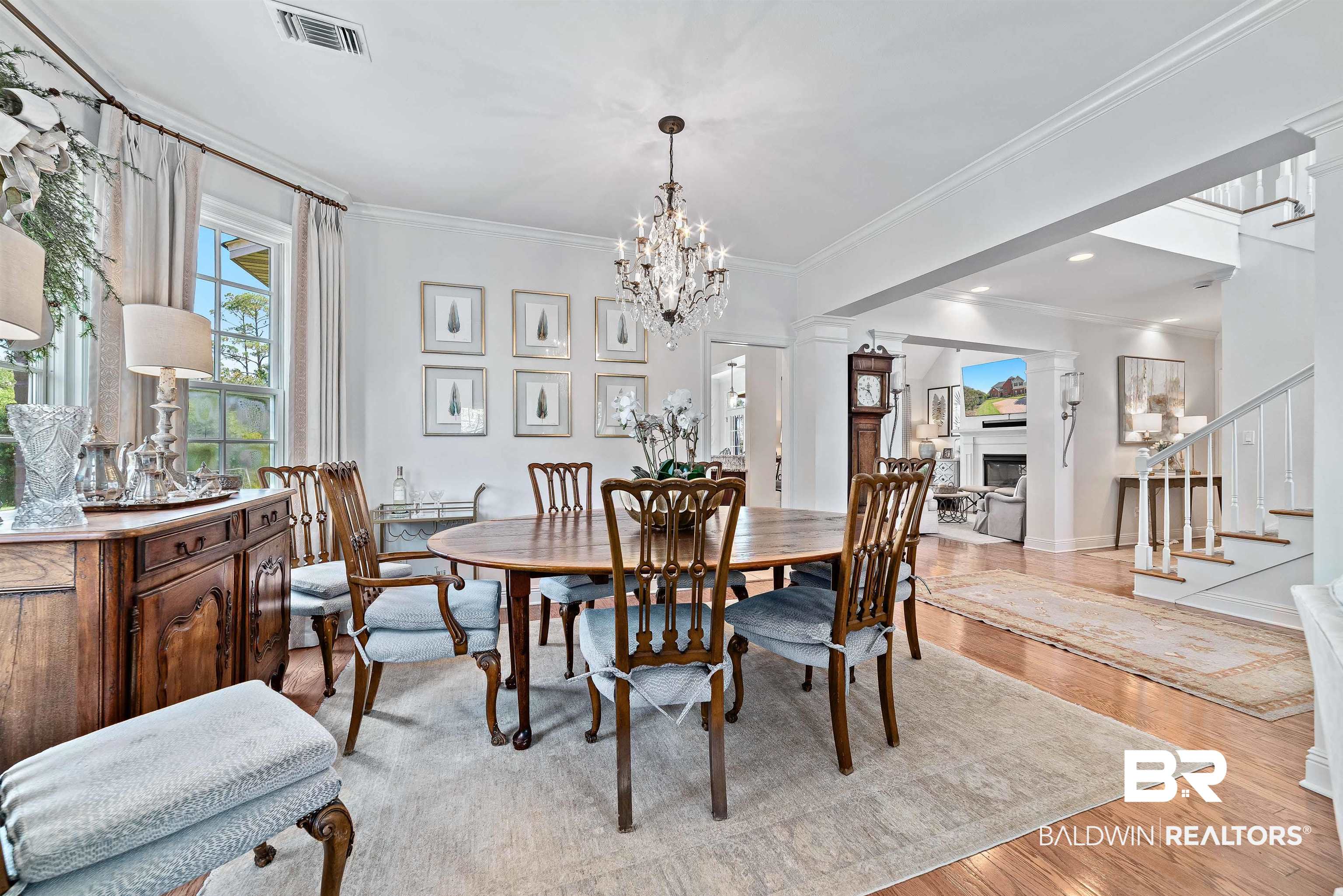 6630 East Quarry Drive Elberta, AL 36530 - Photo 16 of 63 Dining area featuring light wood finished floors, crown molding, a fireplace, ornate columns, and a chandelier