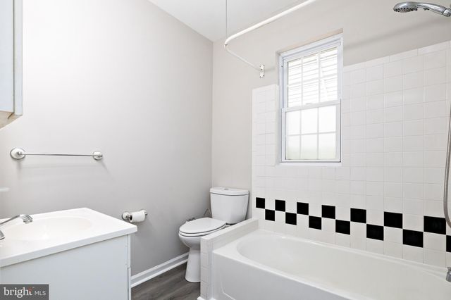 a bathroom with a bathtub a sink a toilet and a window