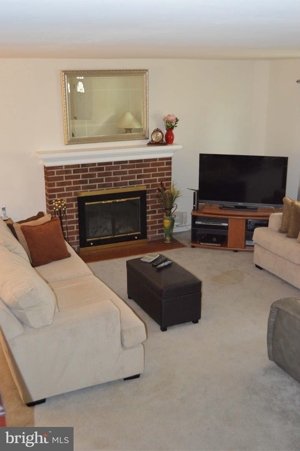 5916 Atteentee Road Springfield, VA 22150 - Photo 5 of 24 a living room with furniture a flat screen tv and a fireplace