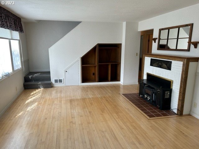 636 Laurel Street Florence, OR 97439 - Photo 12 of 21 a view of empty room with wooden floor and fireplace