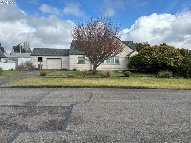 636 Laurel Street Florence, OR 97439 - Photo 2 of 21 a view of a house with a big yard and large trees