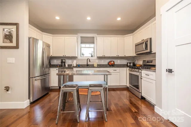 a kitchen with white cabinets and stainless steel appliances