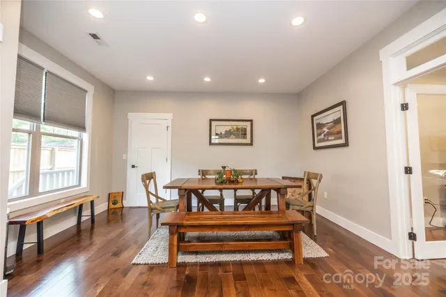 a view of a dining room with furniture a chandelier and wooden floor