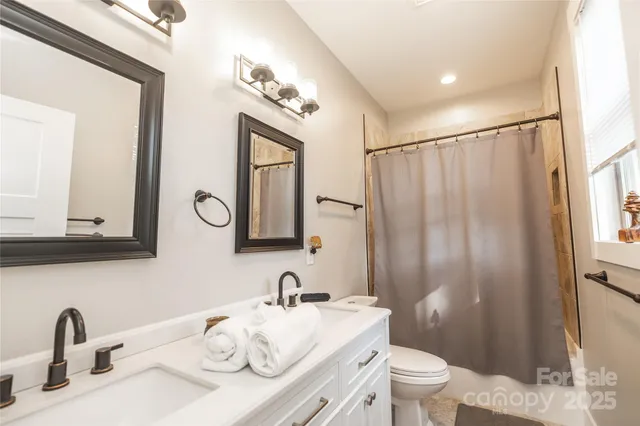a bathroom with a granite countertop sink a toilet and a mirror