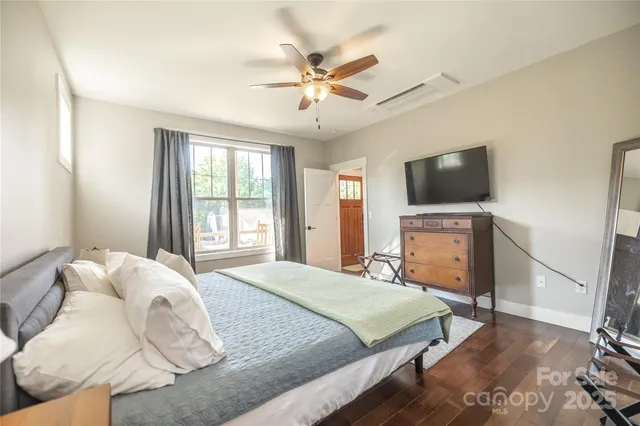 a bedroom with a large bed and a flat screen tv