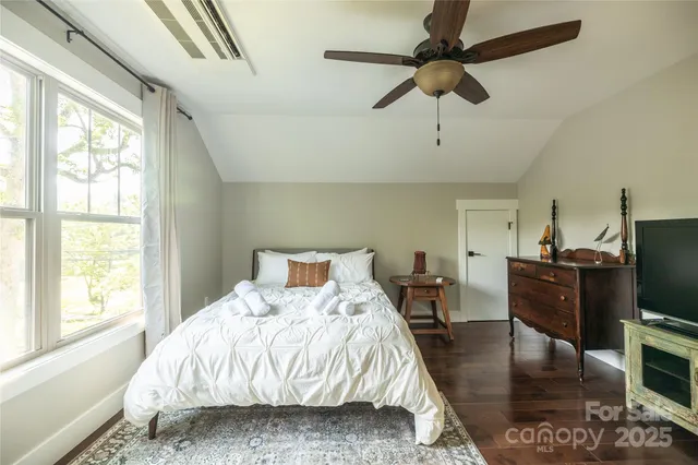 a bedroom with a bed flat screen tv and a large window