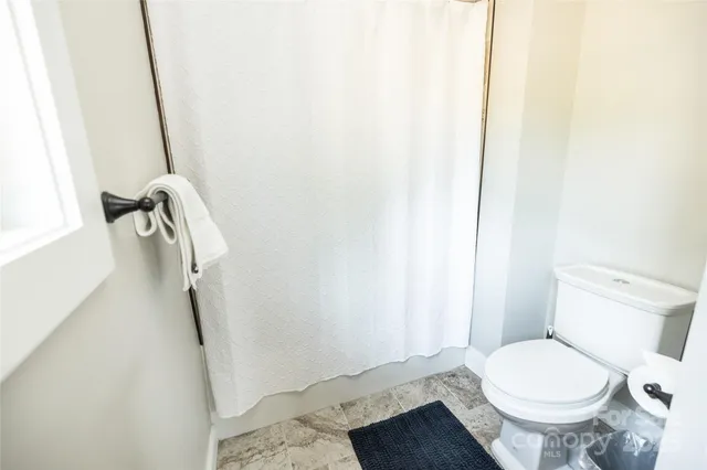 a white toilet sitting next to a shower