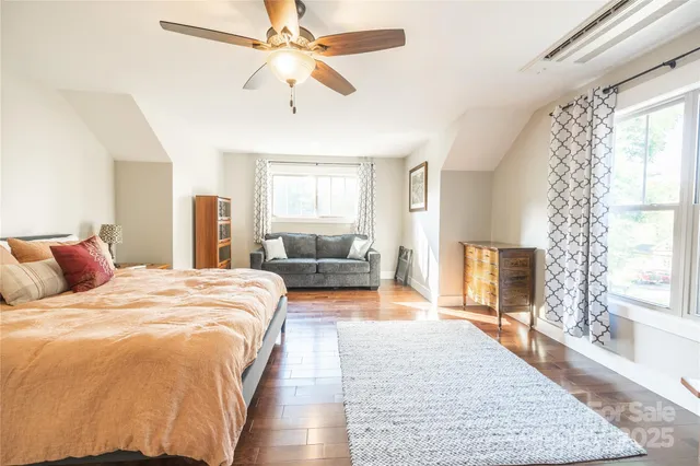 a bedroom with a large bed and a chandelier