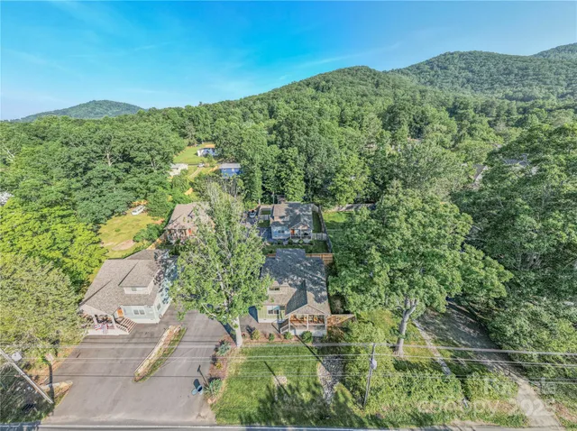 a view of a lush green field with mountains in the background