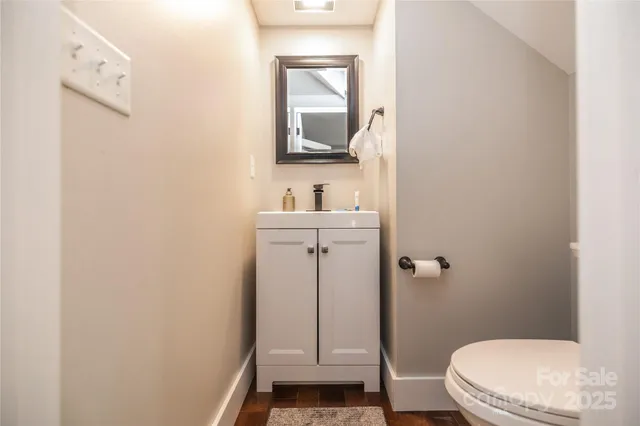 a bathroom with a toilet a sink and mirror