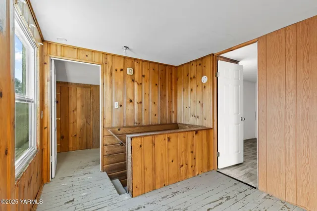 a view of a room with wooden floor and window