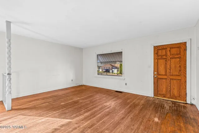 wooden floor in an empty room with a window