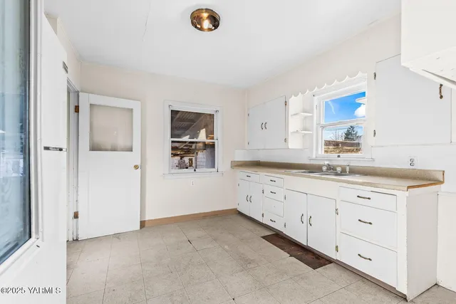 a room with granite countertop white cabinets and a sink