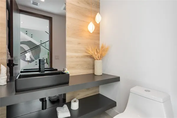 a living room with furniture a ceiling fan and a large window