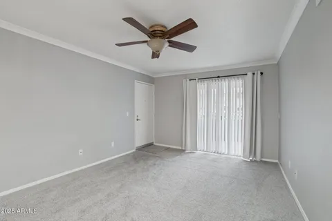 an empty room with ceiling fan and window