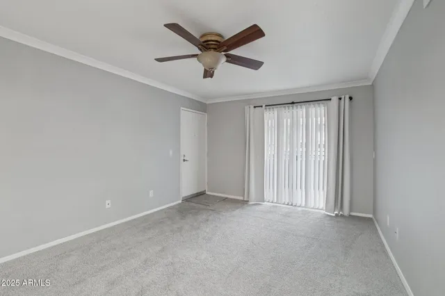 an empty room with ceiling fan and window