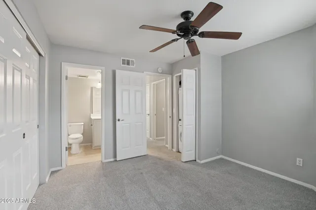 a bathroom with a granite countertop sink a toilet and a mirror