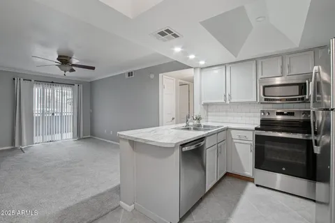 a kitchen with a sink a refrigerator and cabinets