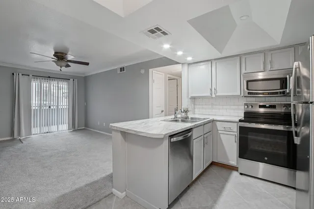 a kitchen with a sink a refrigerator and cabinets