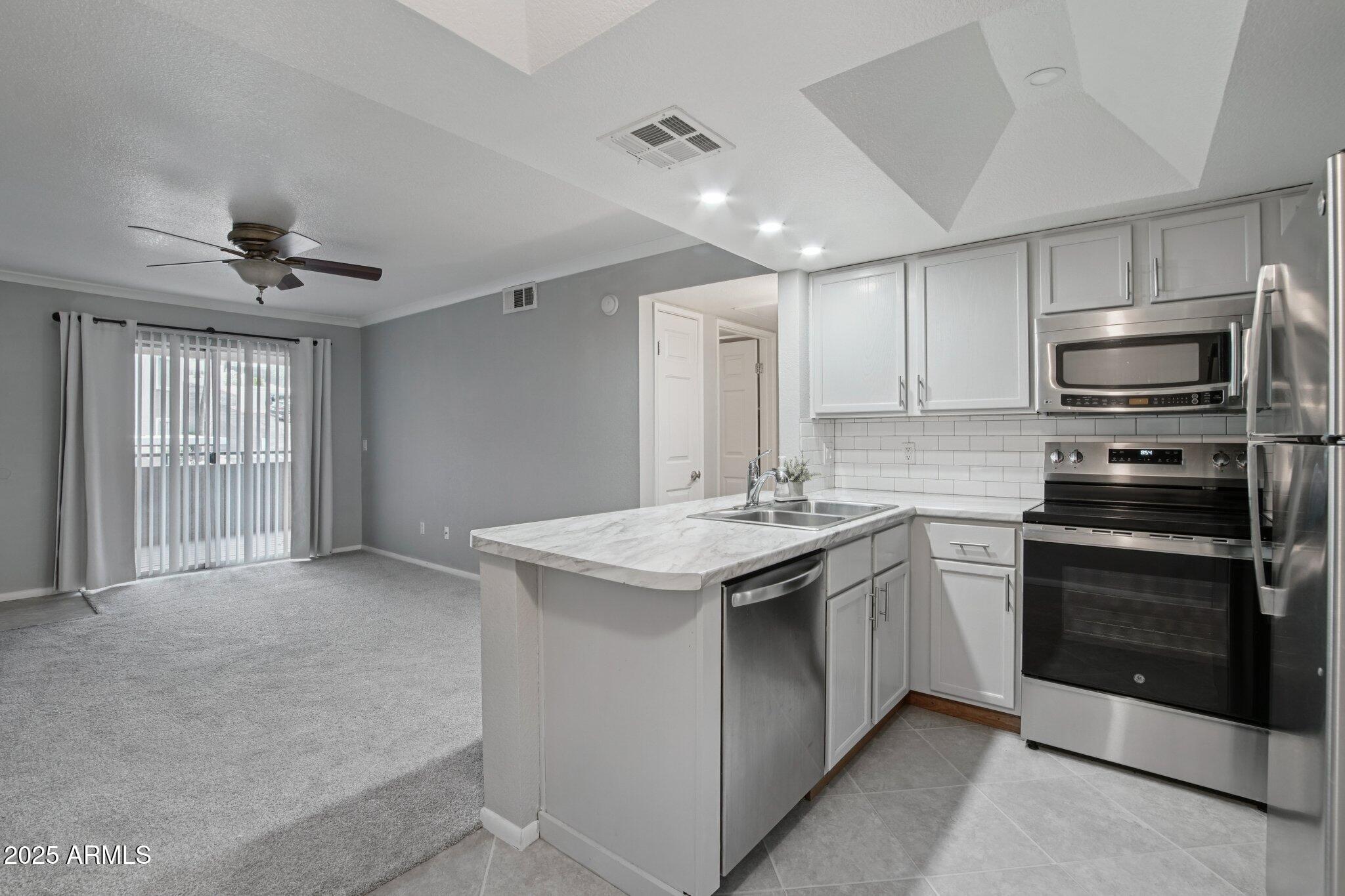1720 East Thunderbird Road, Unit 2024 Phoenix, AZ 85022 - Photo 6 of 23 a kitchen with a sink stainless steel appliances and cabinets