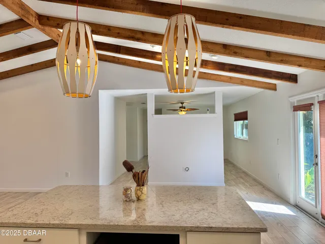 an empty room with a window and a chandelier fan