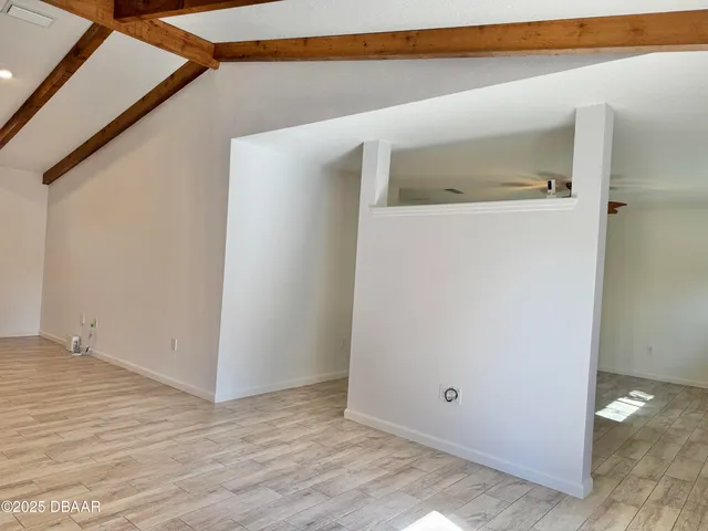 a view of a room with wooden floor and a ceiling fan