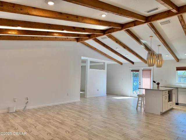 a kitchen with stainless steel appliances granite countertop a refrigerator a stove a sink dishwasher and a refrigerator with wooden floor