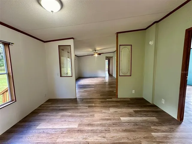 a view of a big room with wooden floor and windows