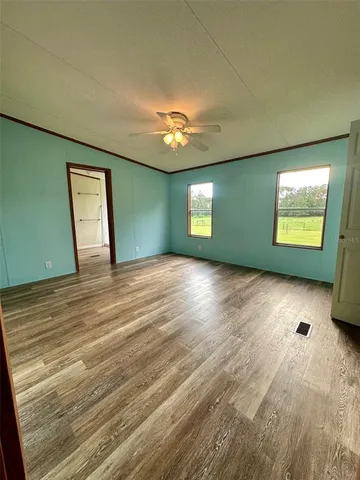 a view of empty room with window and wooden floor