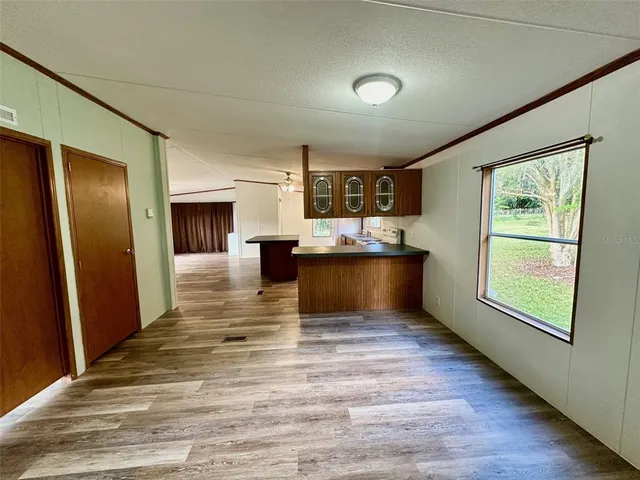 a view of kitchen with wooden floor and electronic appliances