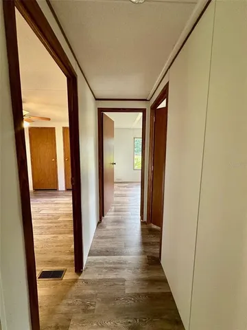 a view of a hallway with wooden floor and staircase