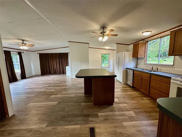 a large kitchen with kitchen island granite countertop a sink counter space cabinets and appliances