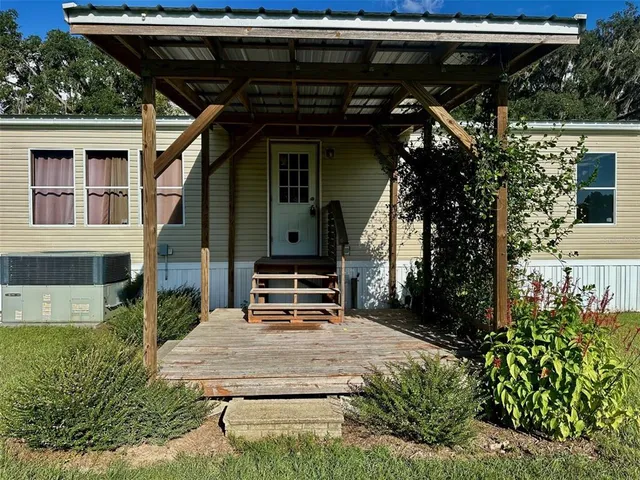 a backyard of a house with large tree and wooden fence