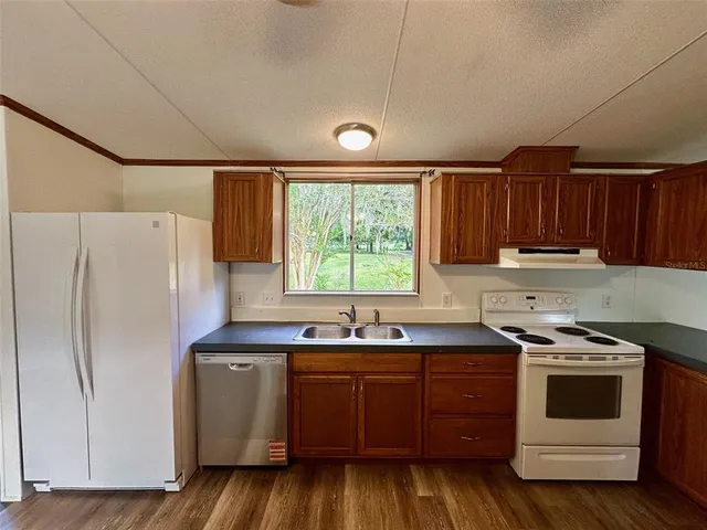 a kitchen with a sink a stove a refrigerator and cabinets
