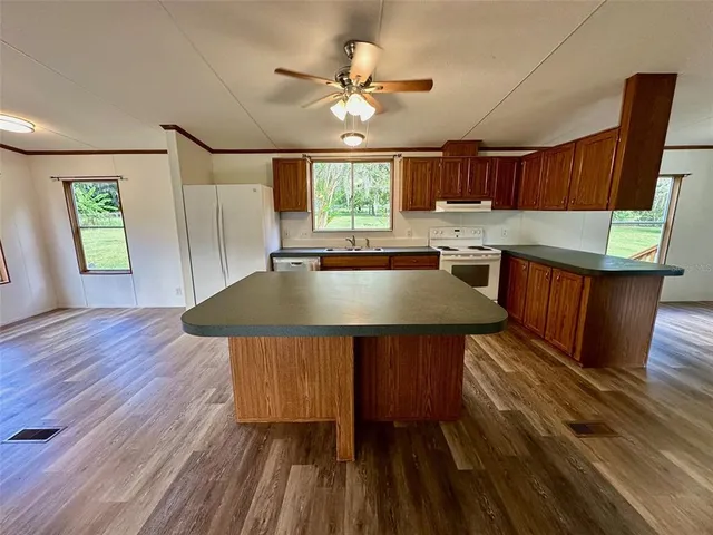 a kitchen with a wooden table chairs and window