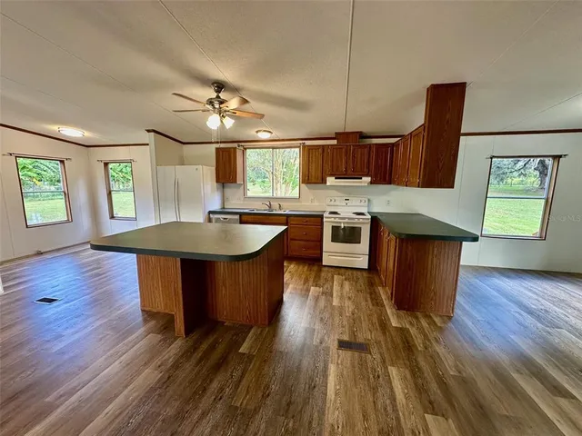 an open kitchen with wooden floor and outdoor seating