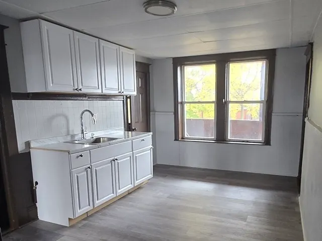 a kitchen with granite countertop white cabinets and sink