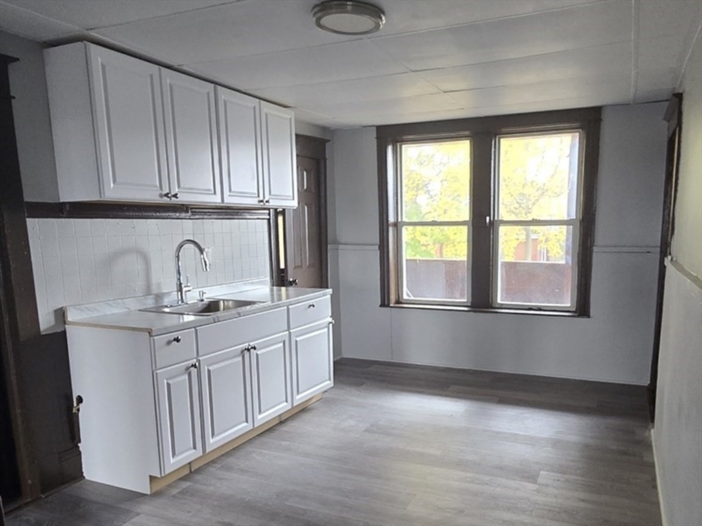a kitchen with granite countertop white cabinets and sink