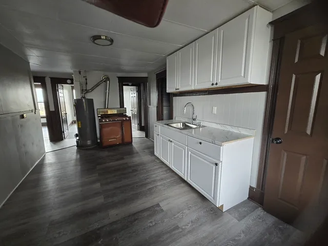 a kitchen with white cabinets and sink