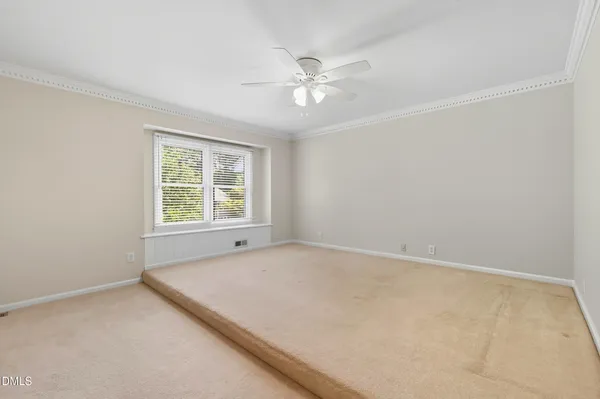 an empty room with a window and a fan